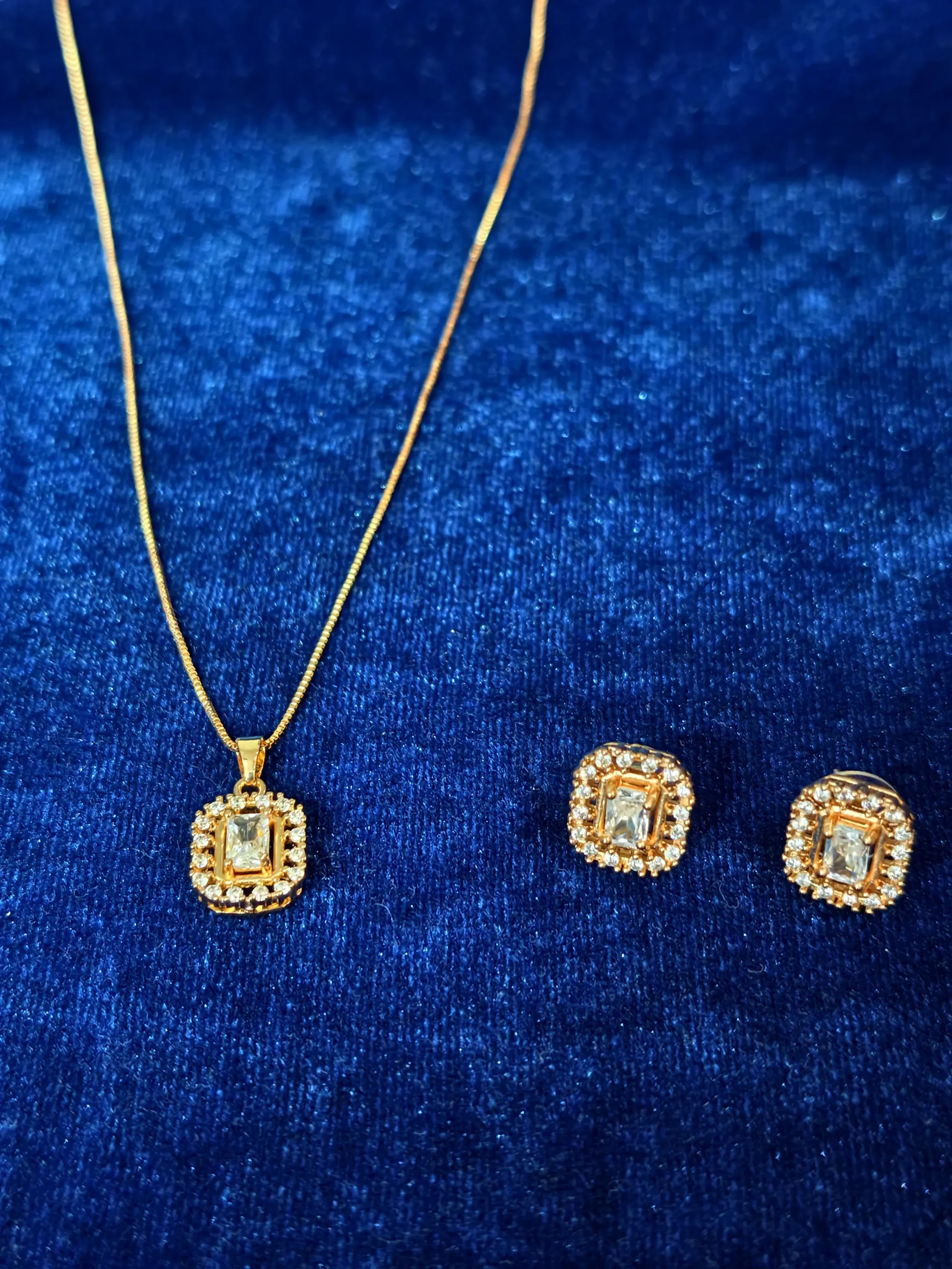 Elegant square-shaped stud earrings featuring a central rectangular crystal surrounded by a sparkling halo of smaller stones
